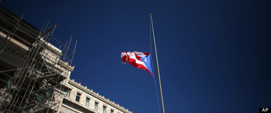 In this photo taken on Thursday, Jan. 11, 2012, the Puerto Rican flag waves in front of the south wing of the Capitol in San Juan, Puerto Rico. A voter referendum will ask the people of the U.S. island territory if they want to amend their Constitution and fire dozens of members of their Senate and House of Representatives as a cost-savings measure, reducing the size of the legislature by almost 30 percent. The answer is almost certain to be a resounding yes. (AP Photo/Ricardo Arduengo)